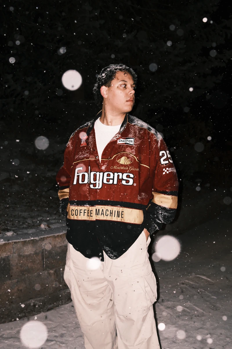 Andre Weiss in a red racing jacket, photographed in falling snow